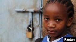 A girl stands next to her locked classroom as a nationwide strike by Kenyan teachers demanding a salary increase left most learning institution paralyzed, in Nairobi, September 5, 2012. 
