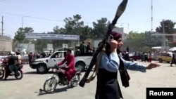 Un miembro del Talibán corre hacia una multitud en el aeropuerto de Kabul, Afganistán, el 16 de agosto de 2021, en una captura de video divulgada por Reuters.