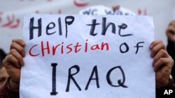 An Iraqi Christian who lives in Lebanon holds a placard during a sit-in, in front of the United Nations Headquarters demanding speeding up their immigration cases in Beirut, Lebanon, Feb. 13, 2017.
