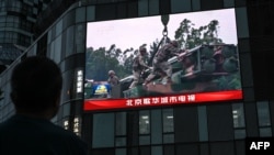 北京街头巨幅电视屏幕播放中国军队东部战区绕台军演的新闻。(2024年5月23日)