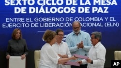 ARCHIVO - La representante del gobierno colombiano Vera Grabe, izquierda, y el comandante colombiano del grupo guerrillero ELN, Pablo Beltrán, intercambian su acuerdo firmado de extensión del alto el fuego en La Habana, Cuba, el 6 de febrero de 2024.