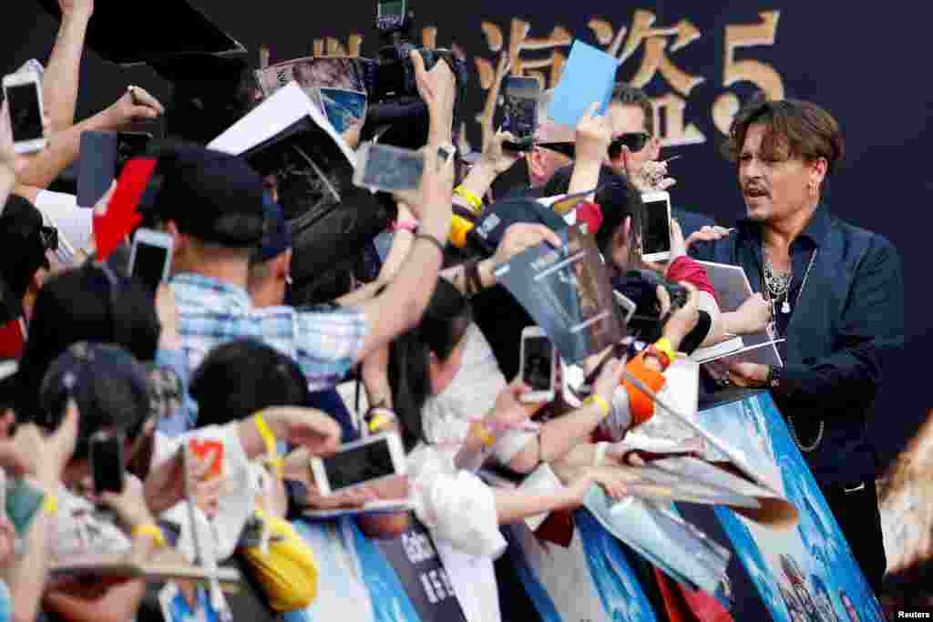 美国演员约翰尼·德普 (Johnny Depp) 在上海参加好莱坞电影巨制《加勒比海盗5:死无对证》( "Pirates of the Caribbean: Dead Men Tell No Tales" )的全球首映礼。影迷们热烈欢迎 (2017年5月11日)。这个电影5月26日开始在中国放映,排片率和票房都很高。