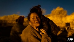 EDITORS NOTE: Graphic content / TOPSHOT - Sulan, a migrant woman from Venezuela, is comforted by her daughter as she cries while retelling her journey to reach El Paso, Texas on April 2, 2024.