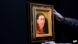 ARCHIVO - Una persona ajusta "Diego y yo" de Frida Kahlo en una exhibición en la casa de subastas Sotheby's durante una vista previa para la prensa de la subasta Modern Evening, el 5 de noviembre de 2021, en Nueva York.