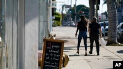 Un cartel anuncia el número de clientes permitidos en una tienda de West Hollywood, en el área de Los Ángeles, California, el 18 de noviembre de 2020.