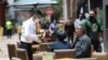 A waiter wearing a mask to curb the spread of the new coronavirus tends to a couple of customers outside a restaurant in the Usaquen neighborhood of Bogota, Colombia, Sept. 3, 2020. 