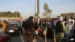 Ratusan orang berkumpul di dekat pos pemeriksaan kontrol evakuasi selama evakuasi yang sedang berlangsung di Bandara Internasional Hamid Karzai, di Kabul, Afghanistan, 25 Agustus 2021. (Foto: AP)