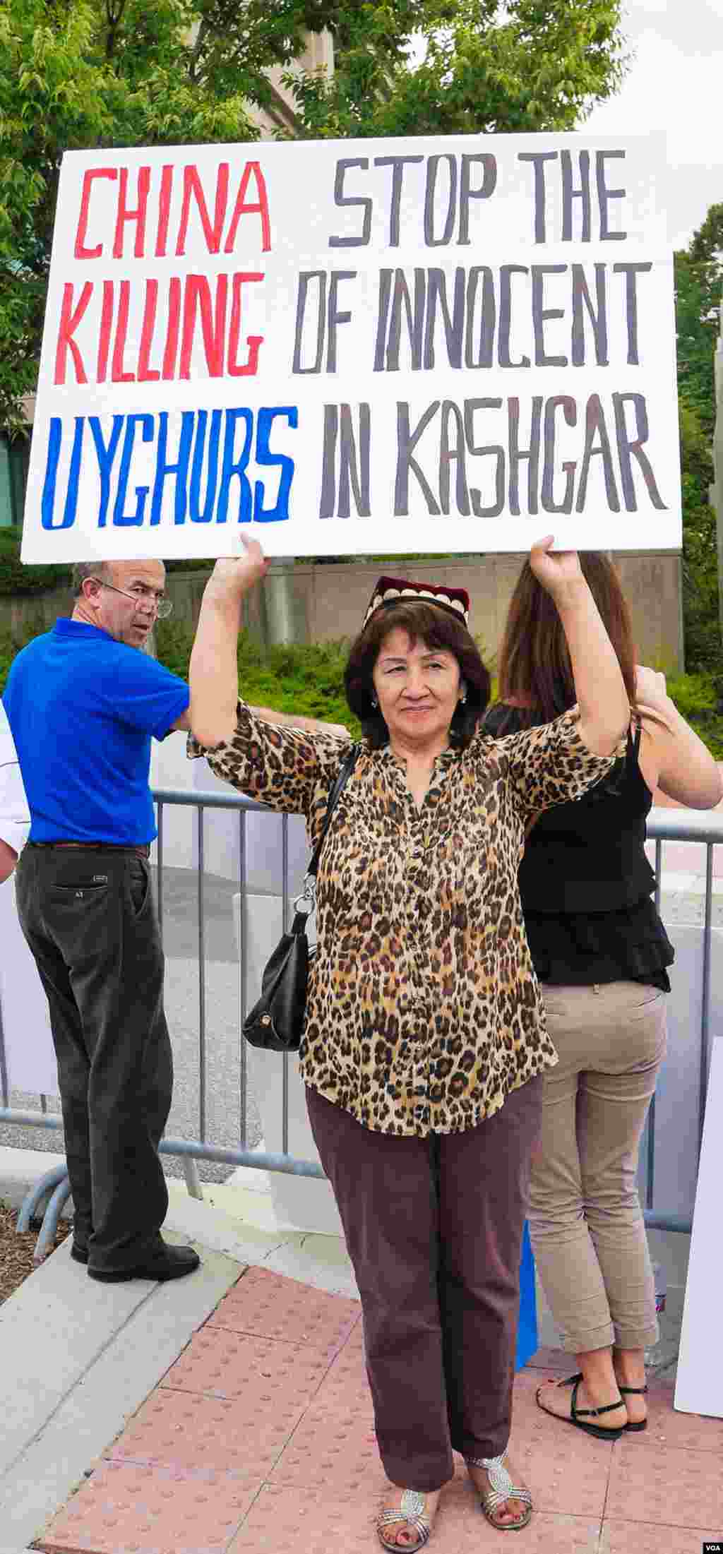 Uyg'urlar Sharqiy Turkiston bayroqlarini ko'tarib, Xitoy elchixonasi qarshisida bu davlatning uyg'urlarga qarshi siyosatini qoralab, namoyish qilmoqda, Vashington, 3-avgust, 2014-yil. Odil Ruzaliev surati