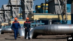 FILE - Workers are seen walking at a gas pipeline station in Uzhhorod, western Ukraine, May 21, 2014.