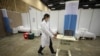Un médico traslada un equipo en un hospital de campaña establecido dentro del centro de convenciones Corferias en Bogotá, Colombia, el lunes 20 de abril de 2020.