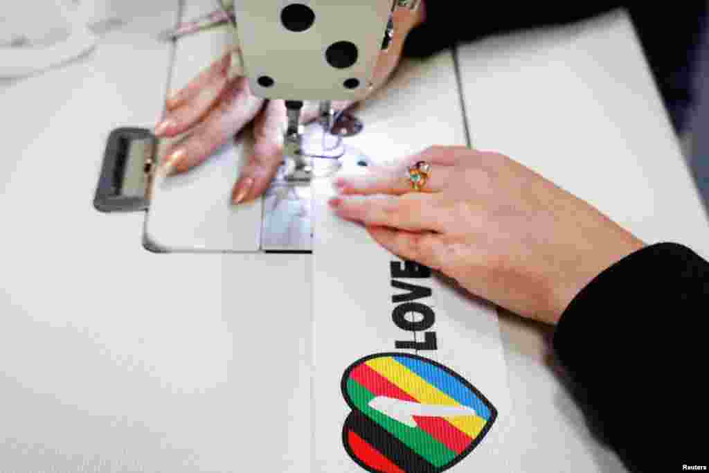 Ante la posibilidad de que diversas selecciones decidieran portar un brazalete con el lema "One Love" en apoyo a la comunidad LGBT+, duramente perseguida en Qatar, la FIFA decidió vetar su uso antes del comienzo del torneo. En la imagen, una trabajadora ultima un brazalete en una planta industrial de Utrech, Países Bajos, el 23 de noviembre de 2022. La empresa ha reportado que tras el veto, las ventas se dispararon hasta agotar existencias.
