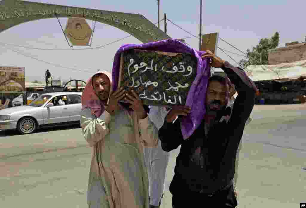 Mourners carry the coffin of a victim of violence before his burial in the Shiite holy city of Najaf. Violence has claimed the lives of 2,417 Iraqis in June, making it the deadliest month so far this year, July 1, 2014.