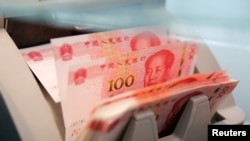 Mata uang kertas 100 yuan di sebuah mesin penghitung di sebuah bank di Beijing, China, 30 Maret 2016. (Foto: REUTERS/Kim Kyung-Hoon/File)