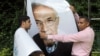 Workers uninstall a billboard showing presidential candidate Ahmed Shafiq in Cairo.