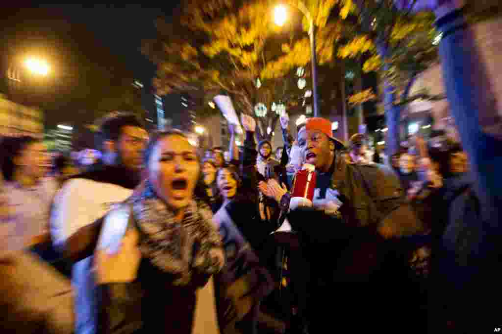 In this photo taken with a zoom effect, protesters march in the street to demonstrate against the election of President-elect Donald Trump in Atlanta, Friday, Nov. 11, 2016