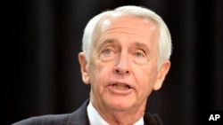 FILE - Kentucky Governor Steve Beshear speaks to the media and a group of Ford employees at the Kentucky Truck Plant in Louisville, Dec. 1, 2015. 