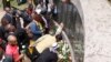 People lay flowers at the U.S. Embassy bombing memorial site in Nairobi, Kenya, Aug. 7, 2013, to mark the 15-year anniversary of the 1998 embassy bombing which killed more than 200 people and injured thousands more.