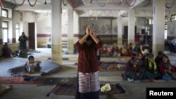 A Tibetan woman offers prayer upon her arrival during an event organized to express solidarity with the victims of violence in Tibet and to those who self-immolated to protest against Chinese rule in Tibet, in Kathmandu, November 17, 2012. 