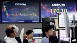 A currency trader watches monitors at the foreign exchange dealing room of the KEB Hana Bank headquarters in Seoul, South Korea, June 8, 2020.