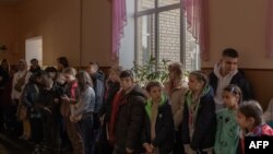 Los niños se reúnen en una escuela durante su evacuación al oeste de Ucrania, desde la ciudad sureña de Jersón, el 30 de octubre de 2023, en medio de la invasión rusa de Ucrania.