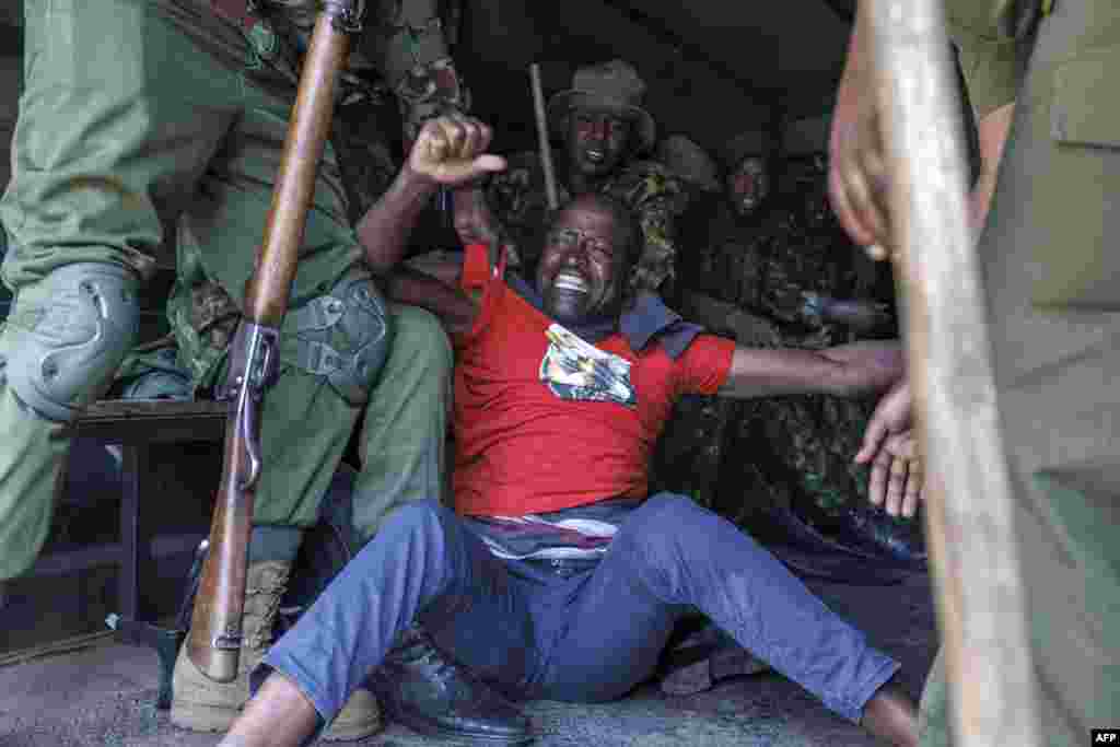 Kenyan police officers arrest an activist during a demonstration to demand the release of government critics who's abductions are unexplained in Nairobi.