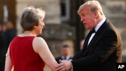 Britain's Prime Minister Theresa May welcomes President Donald Trump ahead of a black-tie dinner at Blenheim Palace in London, July 12, 2018. 