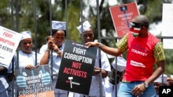 FILE - Demonstrators wear mock prison outfits to show that they want to imprison those engaged in corruption, in Nairobi, Nov. 3, 2016.