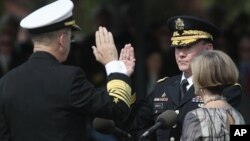 Retiring Joint Chiefs Chairman Adm. Mike Mullen, left, administers the Oath of Office for the new Joint Chiefs Chairman Gen. Martin Dempsey, during a 'Change of Office' ceremony at Ft. Myer in Arlington, Virginia, September 30, 2011. Holding the bible is