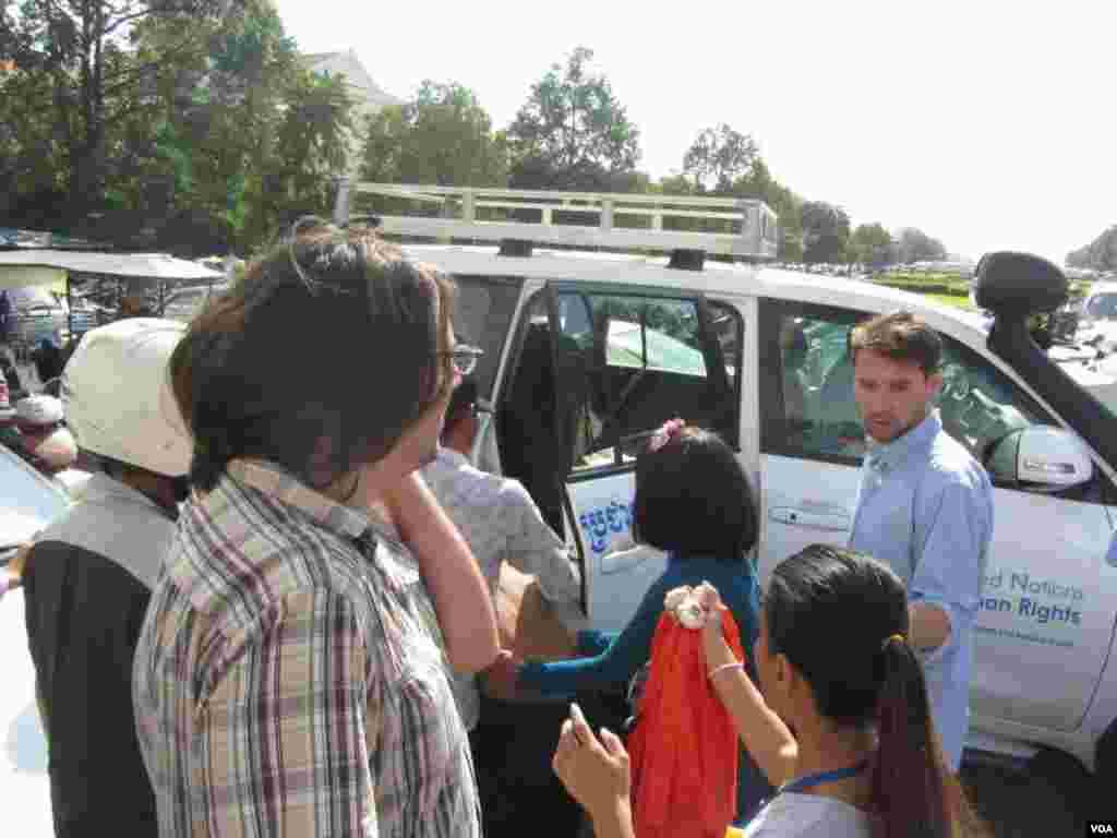 A security guard, severely beaten by angry protesters, is being taken away in a UN car for treatment, Phnom Penh, Cambodia, July 15, 2014. (Khoun Theara/VOA)