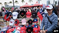 2024年1月7日，總統大選前一星期，高雄，一名街頭小販在主要反對黨國民黨的競選集會上出售旗幟和帽子。 （法新社）