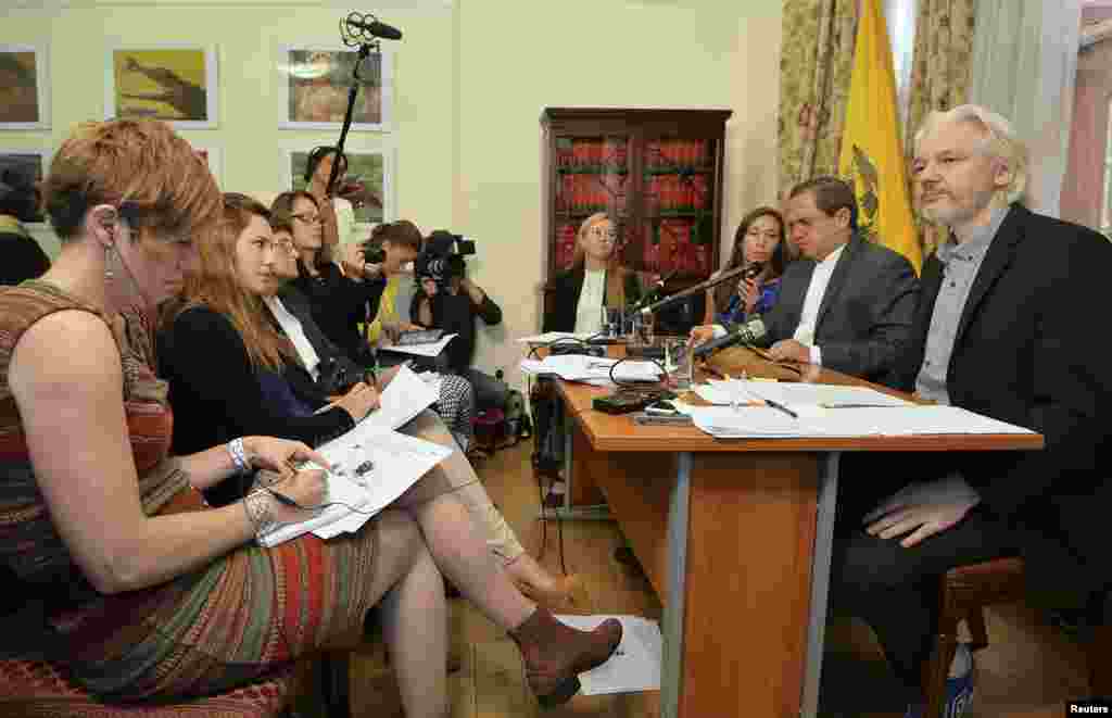 WikiLeaks founder Julian Assange (right) listens as Ecuador's Foreign Affairs Minister Ricardo Patino (second from right) speaks during a news conference at the Ecuadorian embassy, in central London, Aug. 18, 2014.