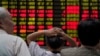 Investors look at an electronic board showing stock information at a brokerage house in Shanghai, China, June 20, 2018. 