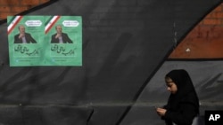 A pedestrian walks past campaign posters for parliamentary election candidate Majid Hajifaraji at Enqelab-e-Eslami (Islamic Revolution) street in downtown Tehran, Iran, Thursday, Feb. 13, 2020. Thousands of Iranian candidates approved to run in…