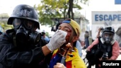 Seorang demonstran yang luka-luka dibantu oleh petuas keamanan saat protes menentang pemerintahan Presiden Venezuela Nicolas Maduro di Caracas, Venezuela, 22 Juli 2017.