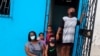 Una familias usa máscaras para protegerse contra la propagación del nuevo coronavirus mientras esperan afuera de su casa en el vecindario de Cristo del Consuelo para recibir alimentos del gobierno local de Guayaquil, Ecuador.