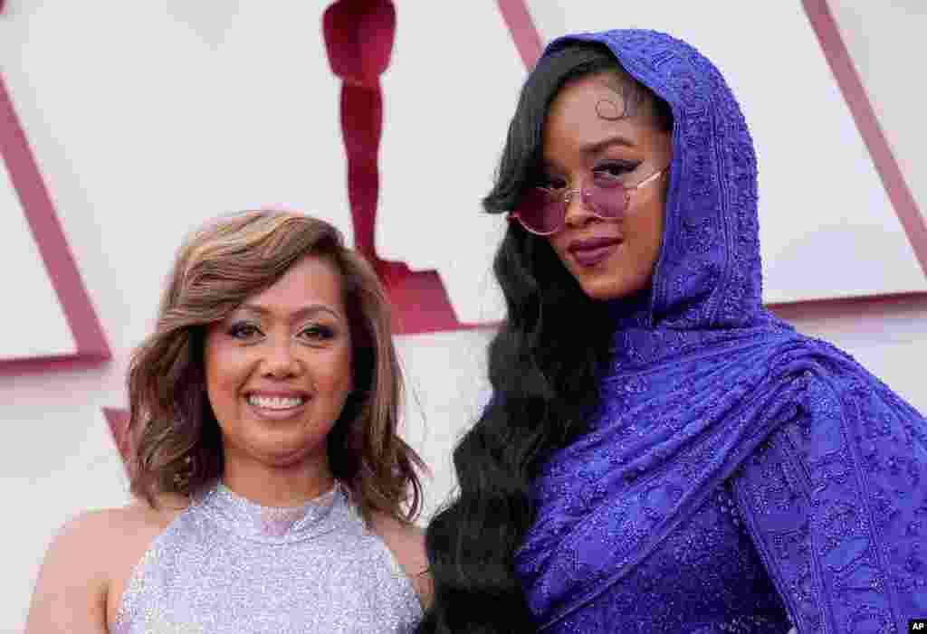 Agnes Wilson, left, and H.E.R. arrive at the Oscars on Sunday, April 25, 2021, at Union Station in Los Angeles. (AP Photo/Chris Pizzello, Pool)