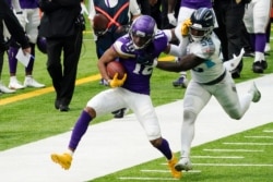 FILE - Minnesota Vikings wide receiver Justin Jefferson, left, tries to break a tackle by Tennessee Titans inside linebacker Jayon Brown during the first half of an NFL football game in Minneapolis, Sept. 27, 2020.
