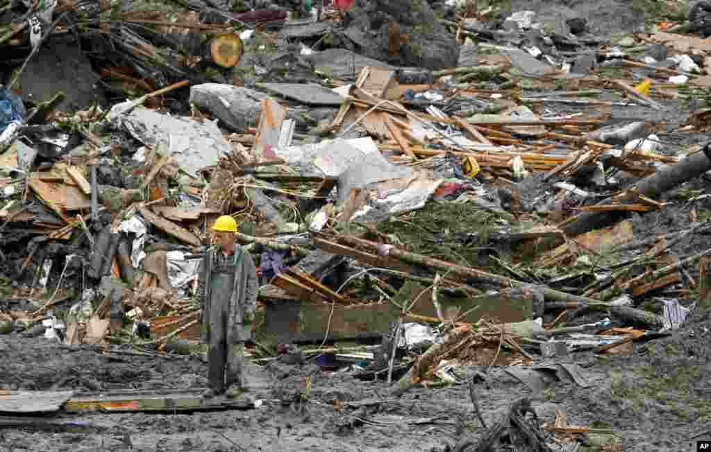 A searcher walks through a massive pile of debris at the scene of a deadly mudslide in Oso, Washington, March 27, 2014.