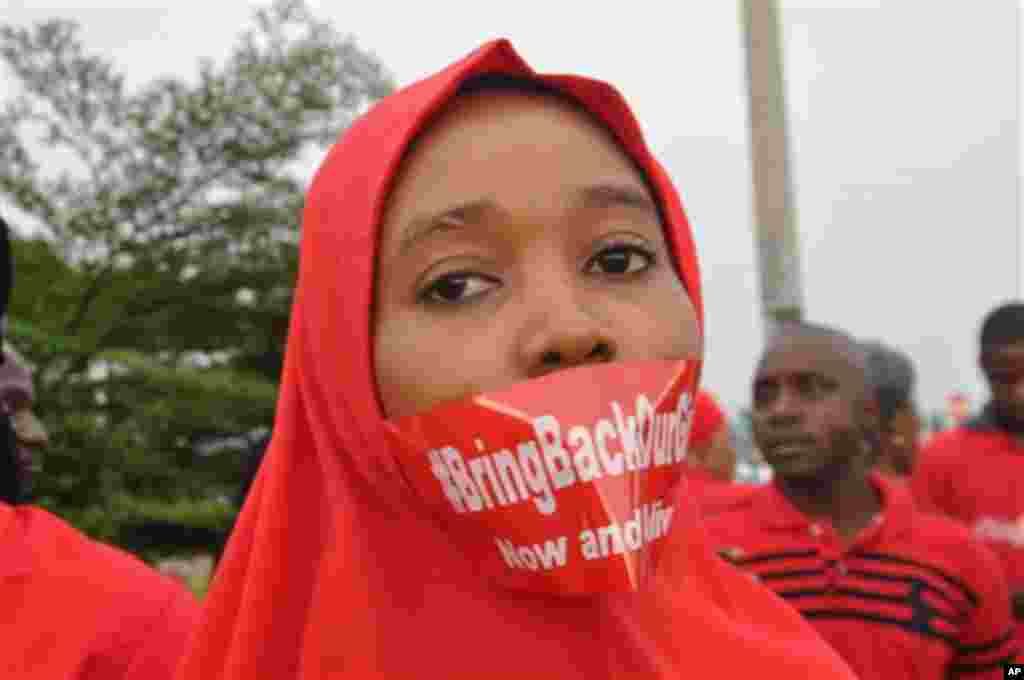 Une femme suit une manifestation à Abuja, au Nigeria, le jeudi 11 septembre 2014, demandant au gouvernement de sauver les jeunes filles enlevées de l'école secondaire publique dans Chibok. (AP Photo / Olamikan Gbemiga)