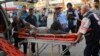 ARCHIVO - Periodistas observan cómo un palestino herido en un bombardeo israelí es llevado a un hospital en Deir el-Balah, Franja de Gaza, el lunes 16 de octubre de 2023.