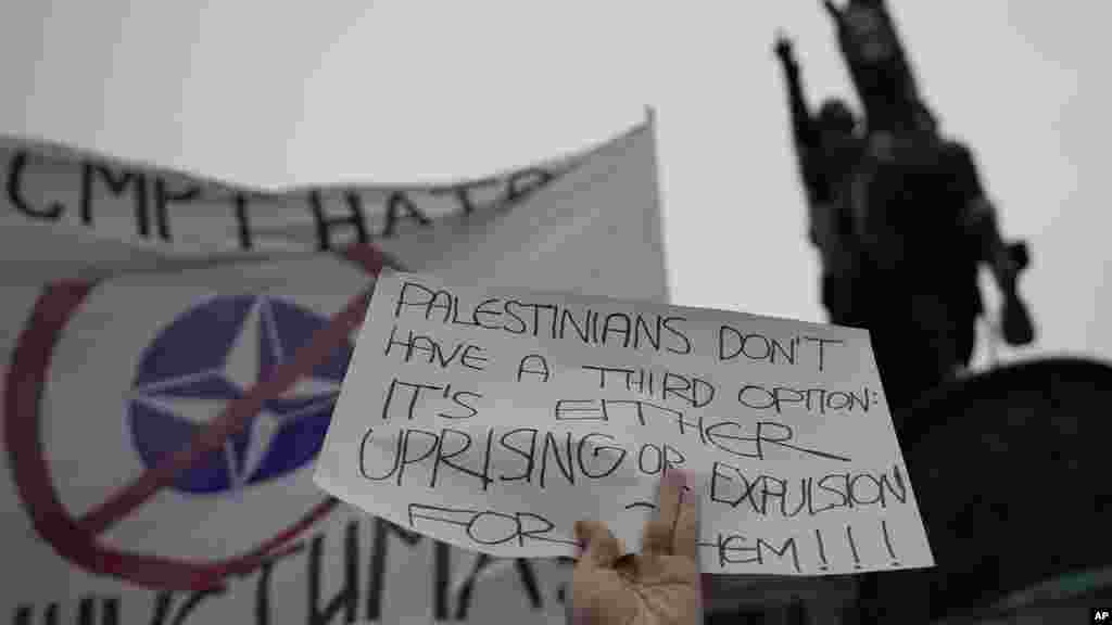 Un manifestante ondea una bandera contra la OTAN que dice: "¡Muerte a los fascistas de la OTAN!" durante una manifestación a favor de los palestinos en Belgrado, Serbia, el 5 de octubre de 2024.