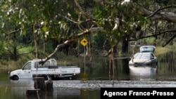 Cars sit in floodwaters in Londonderry, a suburb outside Sydney on March 25, 2021, as flood-stricken residents along Australia's east coast began a massive clean up effort following days of floods. 