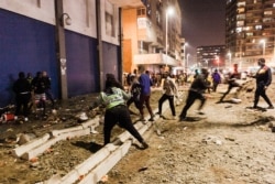 FILE - South Africa Police Services (SAPS) officers stop looters from looting in central Durban, July 11, 2021.