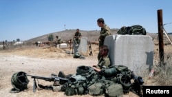 Tentara Israel tampak beristirahat di dekat gerbang perbatasan antara Israel dan Syria di wilayah Golan Heights yang dikontrol oleh Israel pada 3 Agustus 2020. (Foto: Reuters/Ronen Zvulun)