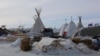  Both chopped firewood and donated wood for building shelter were buried under snow this week as a blizzard passed through the camp (E. Sarai / VOA)
