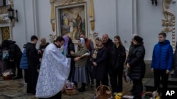 Fieles cristianos ortodoxos y sus canastas de Pascua tradicionales son bendecidos durante el Domingo de Pascua en el complejo monástico de Pechersk Lavra, Kiev, el domingo 16 de abril de 2023. (Foto AP/Bernat Armangue)