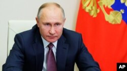 Russian President Vladimir Putin delivers his New Year address to members of the government, via teleconference call, at the Novo-Ogaryovo state residence outside Moscow, Russia, Dec. 24, 2020. 