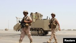 FILE - Soldiers from the United Arab Emirates walk past a military vehicle at the airport of Yemen's southern port city of Aden, Aug. 12, 2015. 