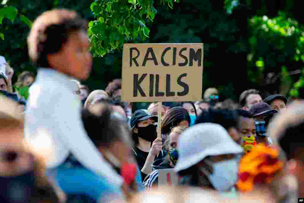 Un ciudadano sostiene un cartel con las palabras "Alto a la violencia policial racista", frente a la embajada de los Estados Unidos en Berlín, Alemania.