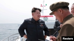 북한 김정은 국방위원회 제1위원장(왼쪽)이 전략잠수함 탄도탄수중시험발사를 참관했다고 조선중앙통신이 지난달 9일 보도했다. (자료사진)